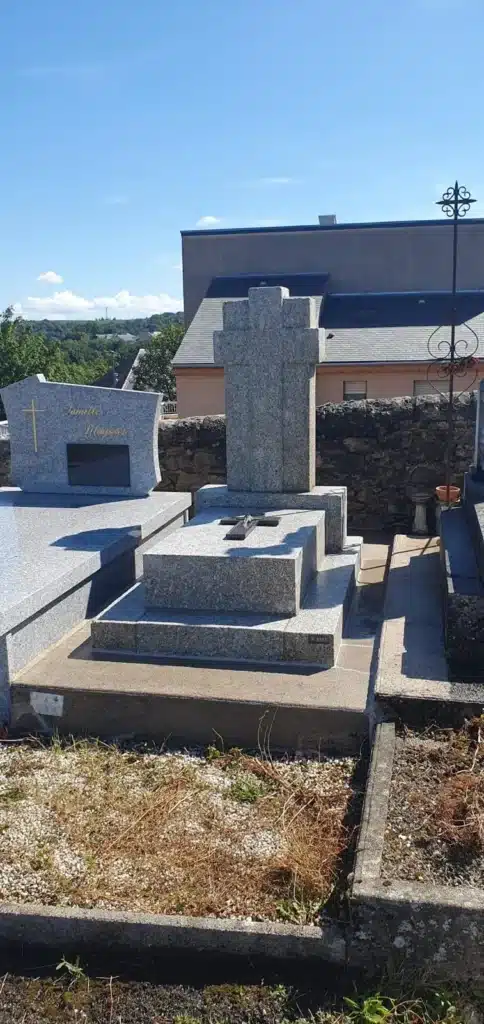 Monument funéraire en granit avec une grande stèle en forme de croix, installé dans un cimetière, conçu pour un hommage durable et élégant. ​​